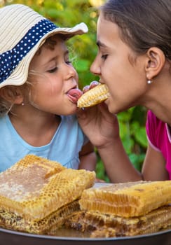 A child eats honey from a comb. Selective focus. Kid.
