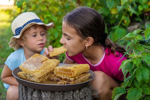 A child eats honey from a comb. Selective focus. Kid.