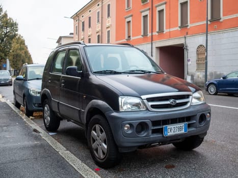 Cremona, Lombardy, Italy October 15th 2024 Small japanese suv parked on the sidewalk of an urban street, showcasing city parking challenges