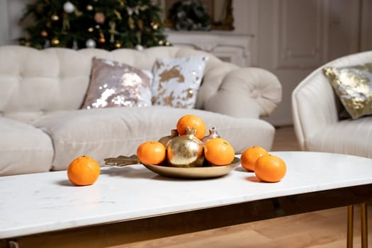 Winter still life . cotton and tangerines on a wooden table. Cotton in white vase. White wall, wooden table.