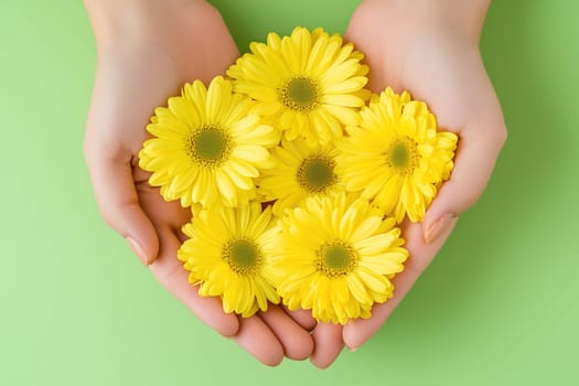 Two hands hold a beautiful collection of bright yellow daisies, highlighting the delicate beauty of flowers in a serene green backdrop, conveying a sense of peace and affection.