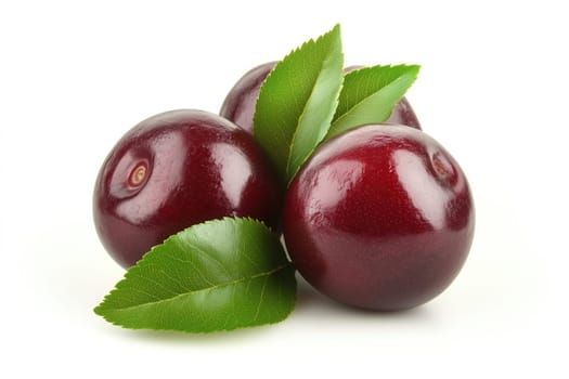 Three dark red plums with a glossy surface are arranged artistically, complemented by vibrant green leaves, highlighting their freshness and natural beauty.