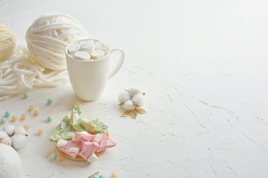 Savor a delicious hot chocolate with candies, marshmallows, and a touch of yarn for a cozy ambiance