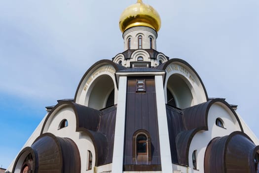 Ornate Orthodox church with a golden dome and intricate arched architectural details, symbolizing Eastern Orthodox tradition against a soft sky