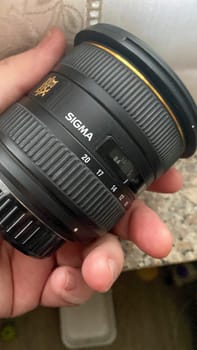 Cremona, Lombardy, Italy October 15th 2024 Photographer holding a sigma 20mm 1.4 dg hsm art wide angle lens, showcasing its design and features