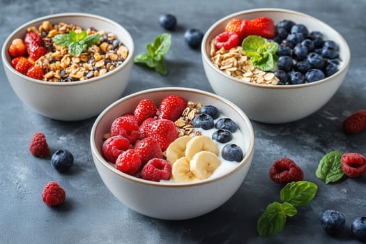 Three bowls filled with a vibrant mix of granola, yogurt, strawberries, blueberries, and raspberries sit on a table, creating a healthy and appetizing breakfast option for anyone.