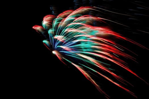 A spectacular burst of vibrant fireworks lighting up the night sky, showcasing an artistic display of colors in stunning reds, greens, and blues, perfect for celebrations.
