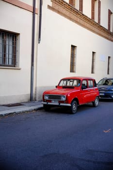 Cremona, Lombardy, Italy - November 7th 2024 Classic red renault 4 parked on the sidewalk of a picturesque european street, showcasing vintage charm and urban transportation