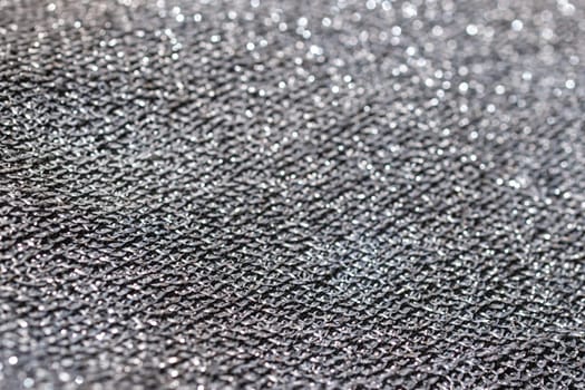 Pure silver wire mesh..Glitter background material.Horizontal blurred metallic surface. Wavy fabric with glitter. Used for backgrounds of fashion products