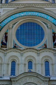 The exterior of a historic cathedral showcasing ornate architectural details, including arched windows and intricate stonework, set against a clear blue sky