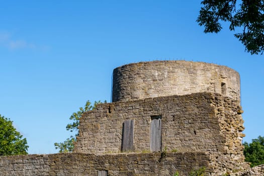 Ancient stone tower ruins standing against a clear blue sky, highlighting medieval architecture and a sense of historical heritage