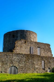 Ancient stone tower ruins standing against a clear blue sky, highlighting medieval architecture and a sense of historical heritage