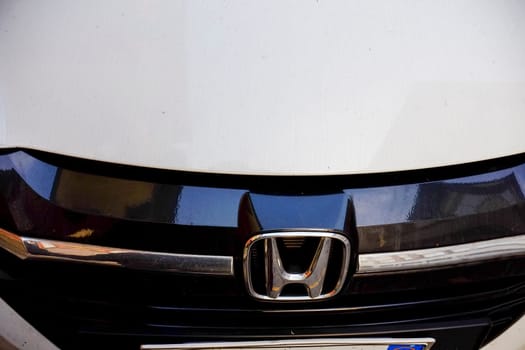 Cremona, Lombardy, Italy - November 7th 2024 Close-up of honda emblem on white car, representing automotive industry, brand recognition, and vehicle design