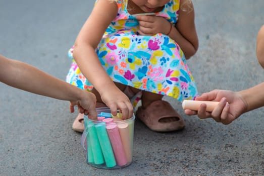 Children draw with chalk on the asphalt. Selective focus. kid.