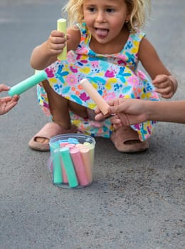 Children draw with chalk on the asphalt. Selective focus. kid.
