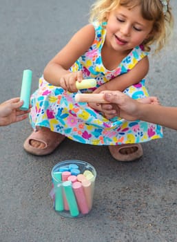 Children draw with chalk on the asphalt. Selective focus. kid.