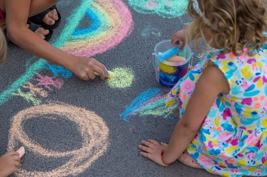 Children draw with chalk on the asphalt. Selective focus. kid.