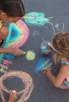 Children draw with chalk on the asphalt. Selective focus. kid.