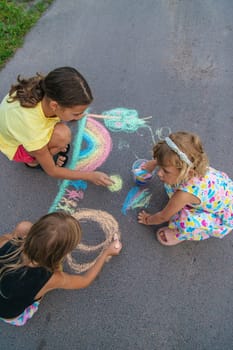 Children draw with chalk on the asphalt. Selective focus. kid.