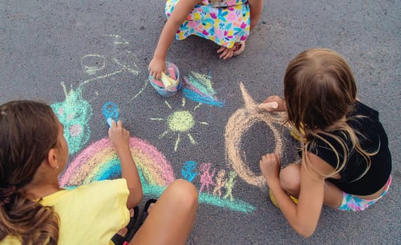 Children draw with chalk on the asphalt. Selective focus. kid.