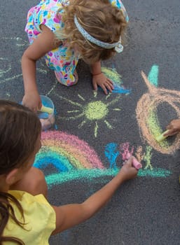 Children draw with chalk on the asphalt. Selective focus. kid.
