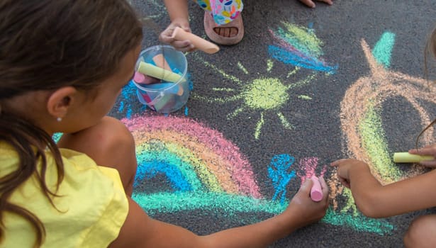 Children draw with chalk on the asphalt. Selective focus. kid.