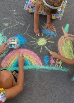 Children draw with chalk on the asphalt. Selective focus. kid.