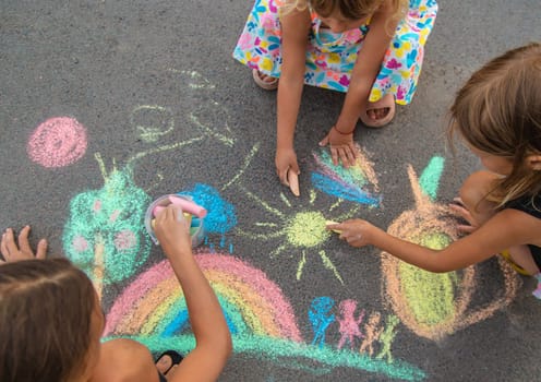 Children draw with chalk on the asphalt. Selective focus. kid.