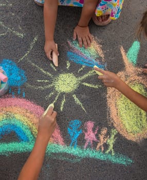 Children draw with chalk on the asphalt. Selective focus. kid.