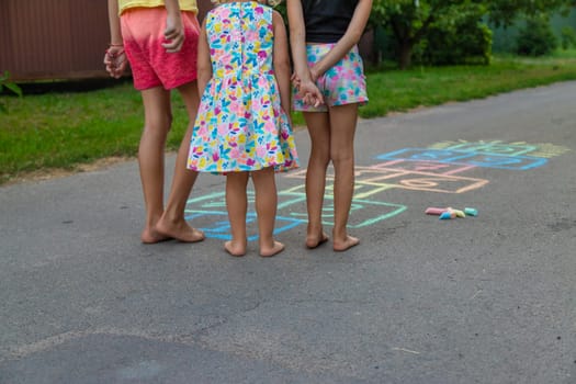 Children jumping hopscotch on the street. Selective focus. kids.