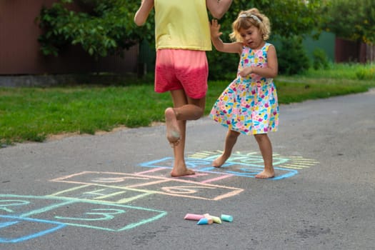 Children jumping hopscotch on the street. Selective focus. kids.