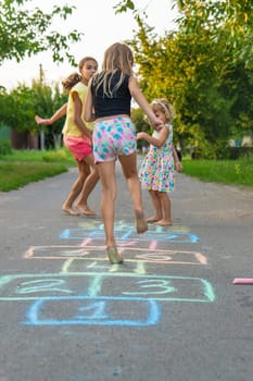 Children jumping hopscotch on the street. Selective focus. kids.