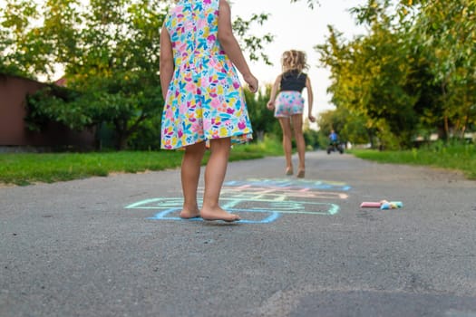 Children jumping hopscotch on the street. Selective focus. kids.