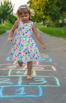 Children jumping hopscotch on the street. Selective focus. kids.