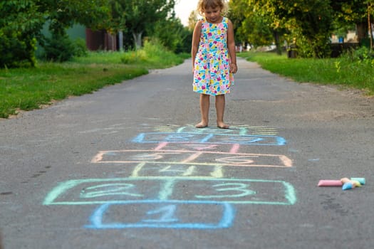 Children jumping hopscotch on the street. Selective focus. kids.