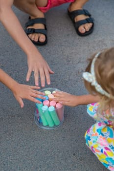 Children draw with chalk on the asphalt. Selective focus. kid.