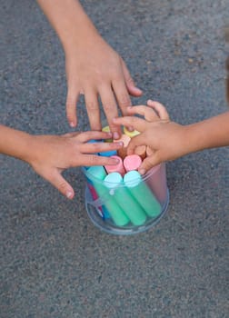Children draw with chalk on the asphalt. Selective focus. kid.