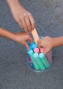Children draw with chalk on the asphalt. Selective focus. kid.