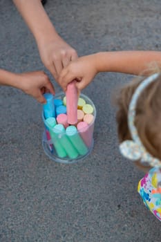 Children draw with chalk on the asphalt. Selective focus. kid.