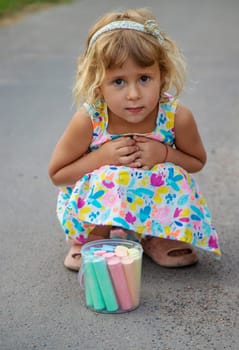 Children draw with chalk on the asphalt. Selective focus. kid.