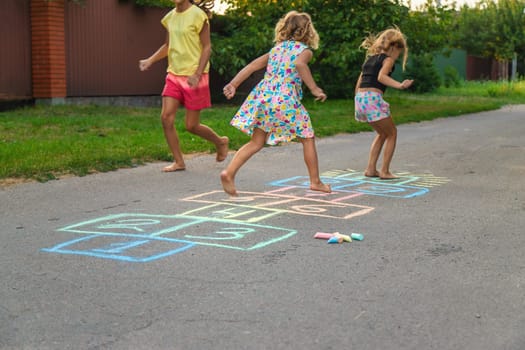 Children jumping hopscotch on the street. Selective focus. kids.