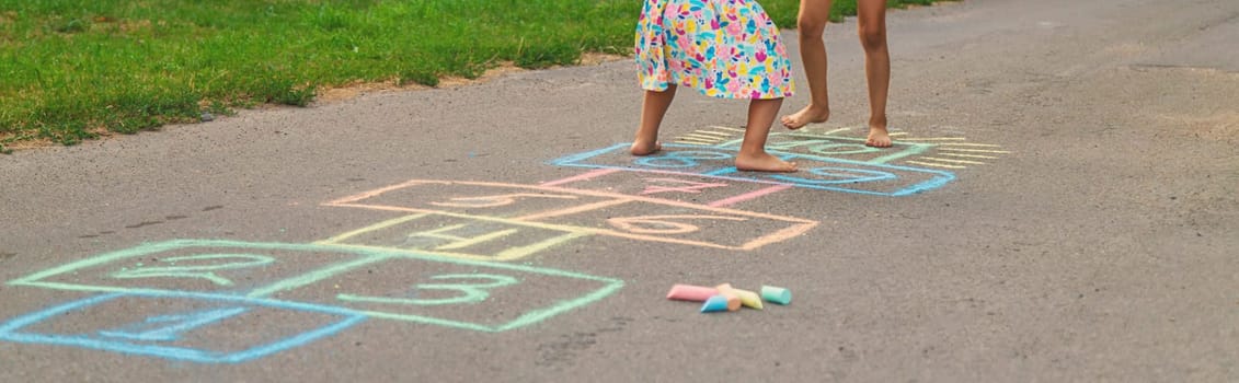 Children jumping hopscotch on the street. Selective focus. kids.