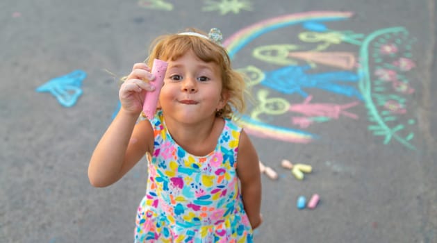 Children draw with chalk on the asphalt. Selective focus. kid.