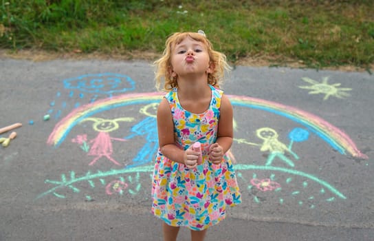Children draw with chalk on the asphalt. Selective focus. kid.
