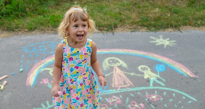 Children draw with chalk on the asphalt. Selective focus. kid.