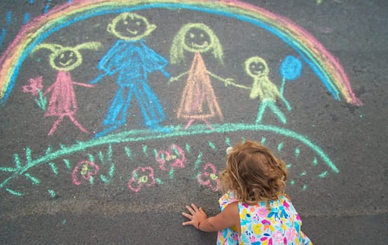 Children draw with chalk on the asphalt. Selective focus. kid.