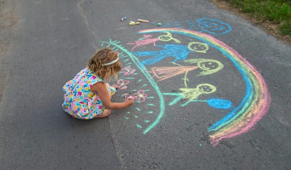 Children draw with chalk on the asphalt. Selective focus. kid.