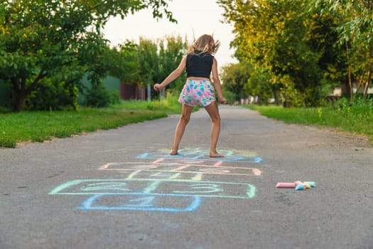 Children jumping hopscotch on the street. Selective focus. kids.