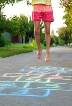 Children jumping hopscotch on the street. Selective focus. kids.