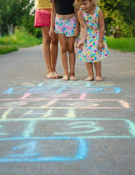 Children jumping hopscotch on the street. Selective focus. kids.